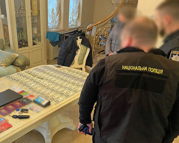 V bytě zadržených bylo nalezeno větší množství stodolarových bankovek. Foto: PČR