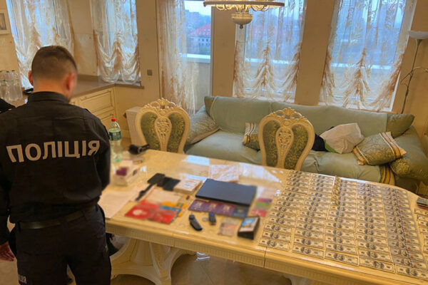 V bytě zadržených bylo nalezeno větší množství stodolarových bankovek. Foto: PČR