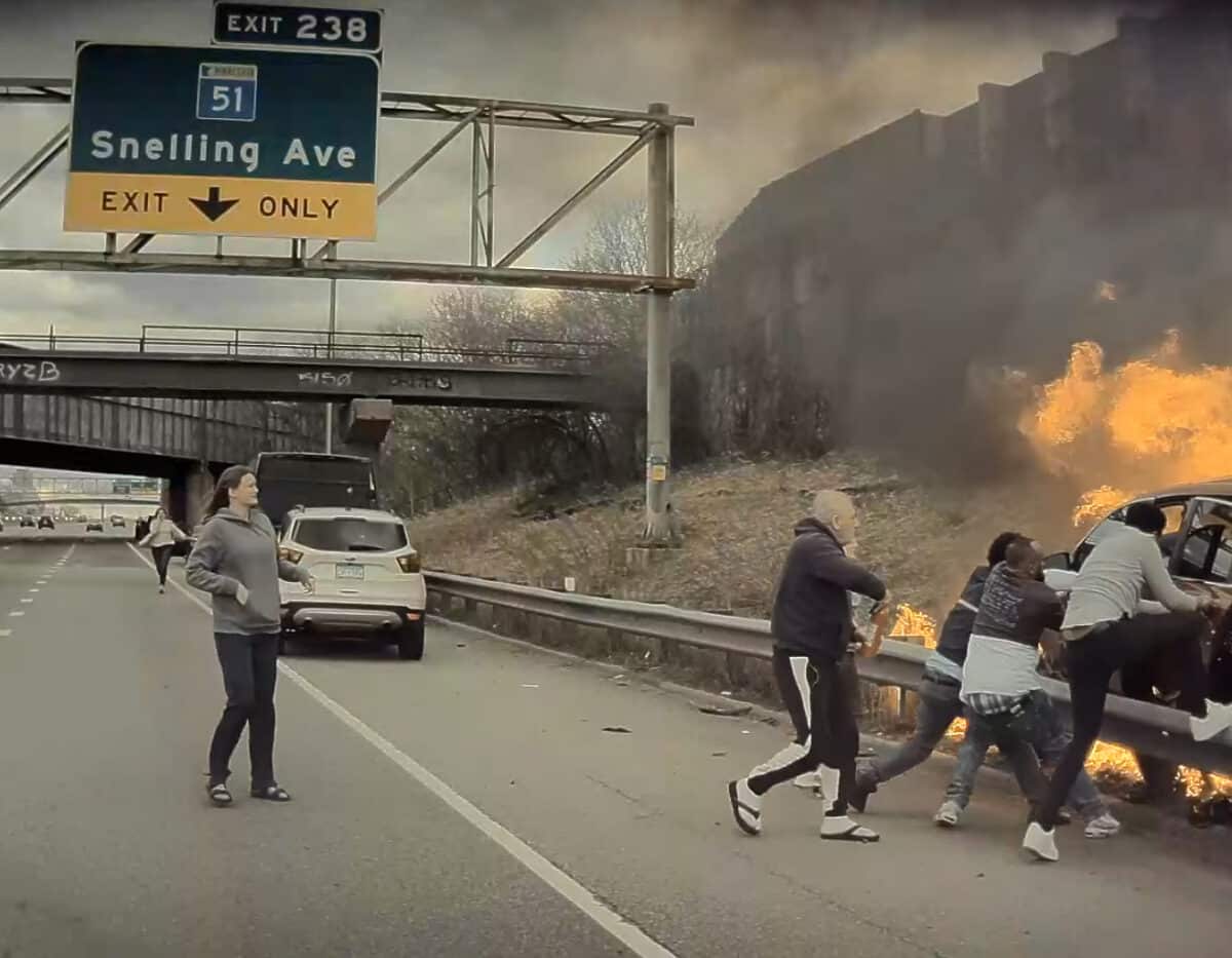 Lidé se snaží zachránit řidiče z hořícího auta po nehodě na dálnici. Zdroj: FB/Kadir Tolla