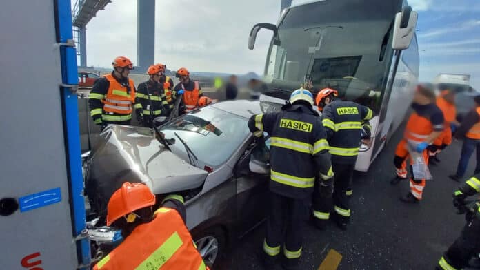 Autobus přimáčkl osobní auto na kamion.