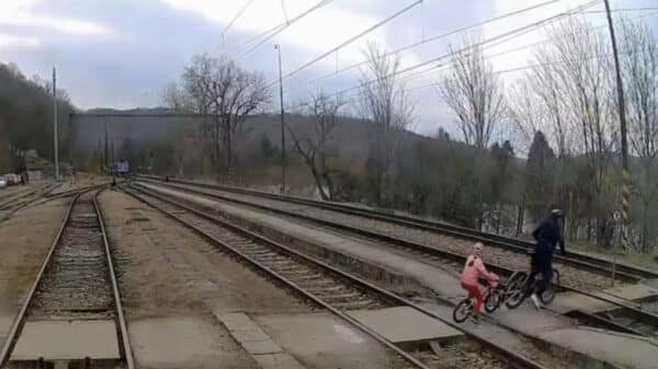 Cyklista s dítětem přechází koleje v Zadní Třebani. Zdroj: IG jarynjarin