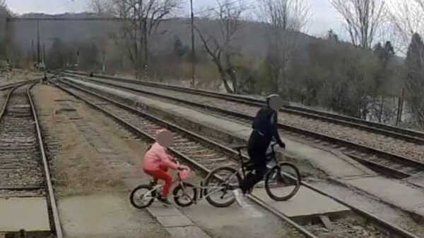 Cyklista s dítětem přechází koleje v Zadní Třebani. Zdroj: IG jarynjarin