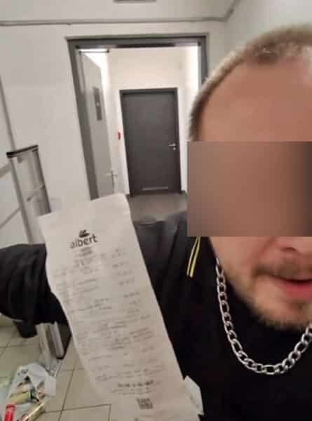Sekuriťák v zázemí prodejny šermuje zákazníkovi účtenkou před obličejem.